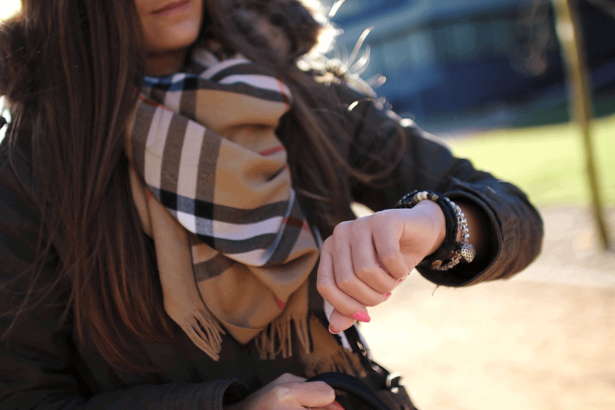 Close-up of polished female checking time on watch