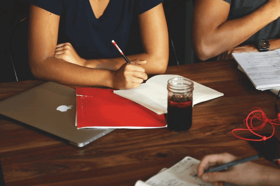 Studious professional group taking notes at desk