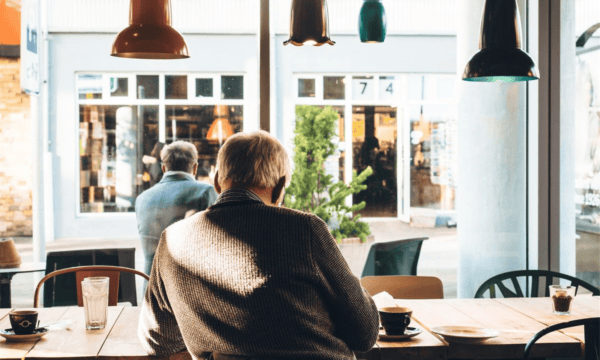 Professional senior man in cafe looking out large windows