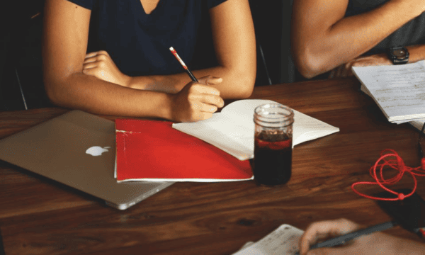 Studious professional group taking notes at desk