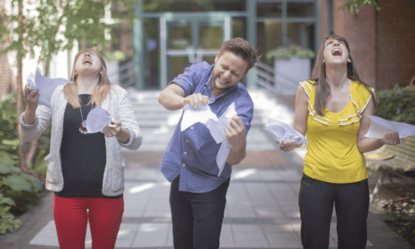 Three people ripping paper up