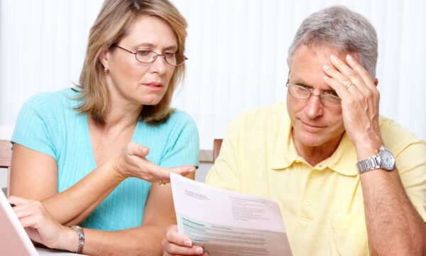 Photo of senior couple planning their retirement with laptop and paper